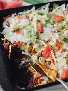 a casserole dish with tortilla chips and vegetables