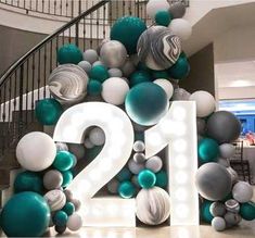 the number twenty two is surrounded by balloons and streamers in front of a spiral staircase