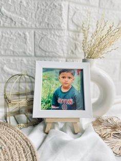 a small wooden easel holding a photograph of a young boy