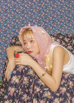 a young woman laying on top of a floral couch