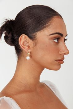 Gold toned alloy earrings Faux pearl Diamante embellished Push closure back Steal the show in our gorgeous Maia earrings. We are obsessed with their unique hanging design and large, faux pearl accent. Perfect for your wedding day or special occasion birthday party. Team them with our Fayette dress for a look that will make heads turn. MATERIAL PEARL/ALLOY