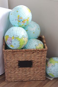 several globes in a wicker basket on the floor