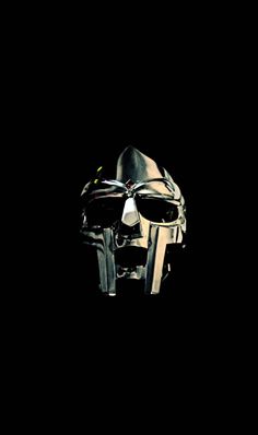 a metal mask with two knives sticking out of it's face in the dark