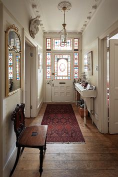 a hallway with stained glass windows and a bench on the floor in front of it