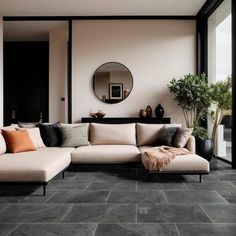 a living room filled with furniture and a large mirror on the wall above it's windows