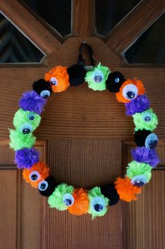 a halloween wreath made out of yarn and fake eyes