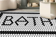 a black and white bathroom rug with the word sale spelled in hexagon tiles