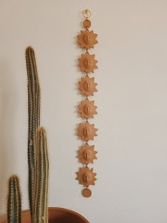 a cactus sitting next to a wooden wall decoration