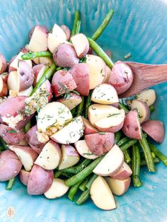 a blue bowl filled with potatoes and green beans