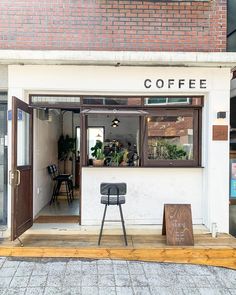 the outside of a coffee shop with chairs and tables