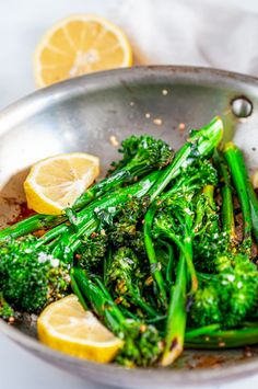 broccoli and lemons are in a pan on the table