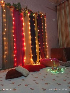 a bed with lights on the wall and pillows in front of it that have been decorated