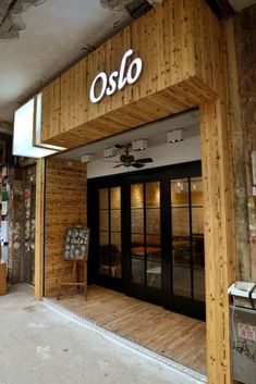 the entrance to an oslo store with sliding glass doors and wood paneled walls