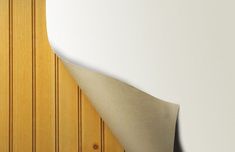 a surfboard leaning up against a wall in a room with white walls and wood paneling