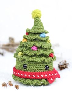 a crocheted christmas tree sitting in the snow