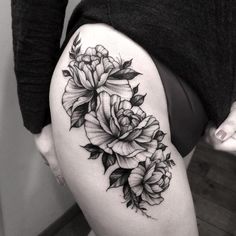 a woman's thigh with flowers and leaves on her thighs, in black and white