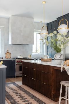 a kitchen with wooden cabinets and white flowers on the counter top, along with an area rug