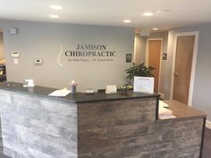 the front desk of a chiropractic office with a plant on it's side