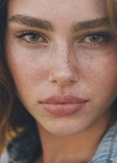 a woman with freckled hair is posing for the camera