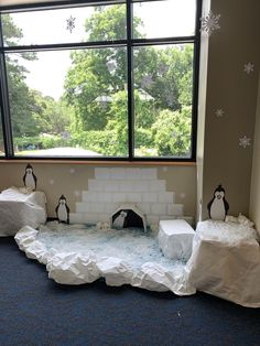 penguins are sitting on ice in front of a window