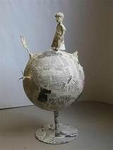 a sculpture of a person standing on top of a globe