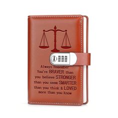 an orange leather journal with a scale and quote on it