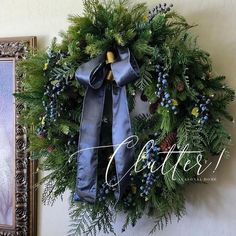 a christmas wreath hanging on the wall next to a painting