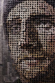 a man's face is made up of hundreds of small round objects in the shape of circles