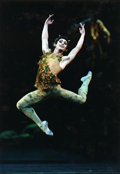 a male ballet dancer is in the air