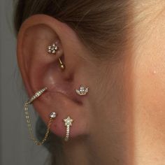 a woman wearing three different ear piercings