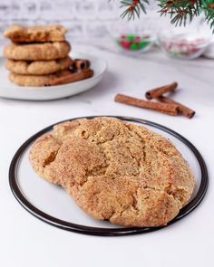 a cookie on a plate next to some cinnamon sticks