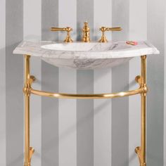 a bathroom sink sitting on top of a marble counter next to a framed mirror in a room