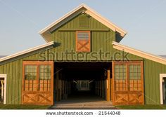 the barn and shed is green with brown trim on it's doors, windows, and shutters