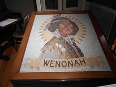 a table with a mosaic on it that says, wenonah and an image of a native american woman