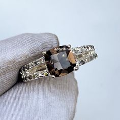 "Smoky Quartz Ring, Natural Cushion Cut Brown Gemstone Ring, Genuine Sterling Silver Ring, November Birthstone, Engagement Ring, Promise ring ❥ Stone - Natural Smoky Quartz  ❥ Stone Size - 6x6mm ❥ Cut Type - Cushion ❥ Accent Stones - Simulated Diamond Cz  ❥ Ring Size: I offer more than one (Contact us if your ring size is not available in the listing) ❥ Color: Silver, Gold, Rose Gold, White Gold or Black Rhodium ❥ Material : 925 Sterling Silver, 14K/18K/22K Solid Gold ---> ❥ Makes a Wonderful Gift for your Girlfriend, Wife, Mother and Friend or Simply an Excellent Addition to Your Jewelry Collection -->IF YOU WANT CUSTOM ENGRAVING ON YOUR RING VISIT OUR LISTING HERE: It's Only 2 USD https://www.etsy.com/listing/1436332485/custom-engaraving - -Here's a link to my HOMEPAGE: Johrifinejeweller Brown Gemstone, Smoky Quartz Ring, Natural Cushions, November Birthstone, Solid Gold Jewelry, Gifts For Your Girlfriend, Cz Ring, Ring Promise, Black Rhodium