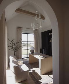 an archway leading into a living room with white furniture