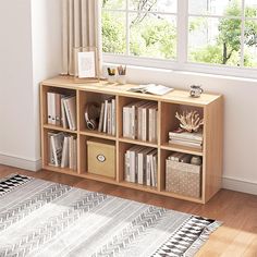 a book shelf with books and other items on it in front of a large window