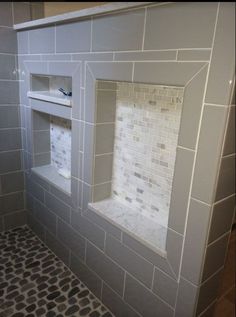 a bathroom with gray and white tile on the walls