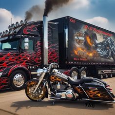 a motorcycle parked next to a semi truck with flames painted on it's side