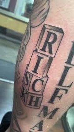 a man's arm with some type of tattoo on it and the words rich rich rich rich