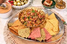 a platter filled with chips and salsa on top of a table next to other food