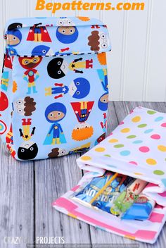 the back pack is sitting next to some children's books and magazines on a wooden table