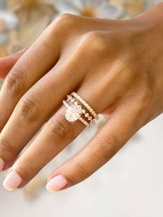 a woman's hand with three rings on her left and one ring on her right