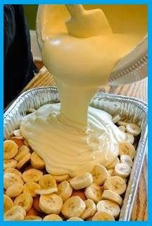 a pan filled with bananas and cream being drizzled on top of it