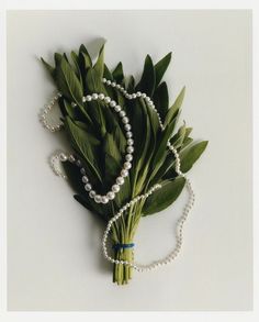 a bouquet of flowers with pearls and green leaves