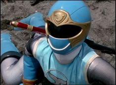 a close up of a person wearing a blue and gold outfit with a baseball bat in his hand