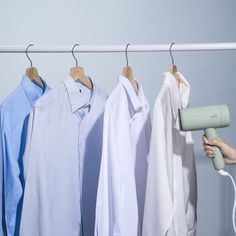 a person is drying clothes on a rail with a hair dryer next to them