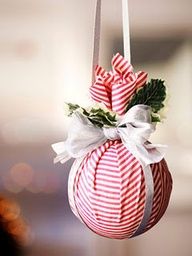 a red and white striped ornament hanging from a string with a bow on it