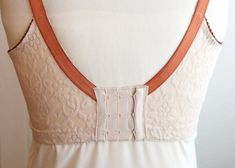 a white dress with an orange belt on it