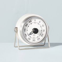 an alarm clock sitting on top of a metal stand